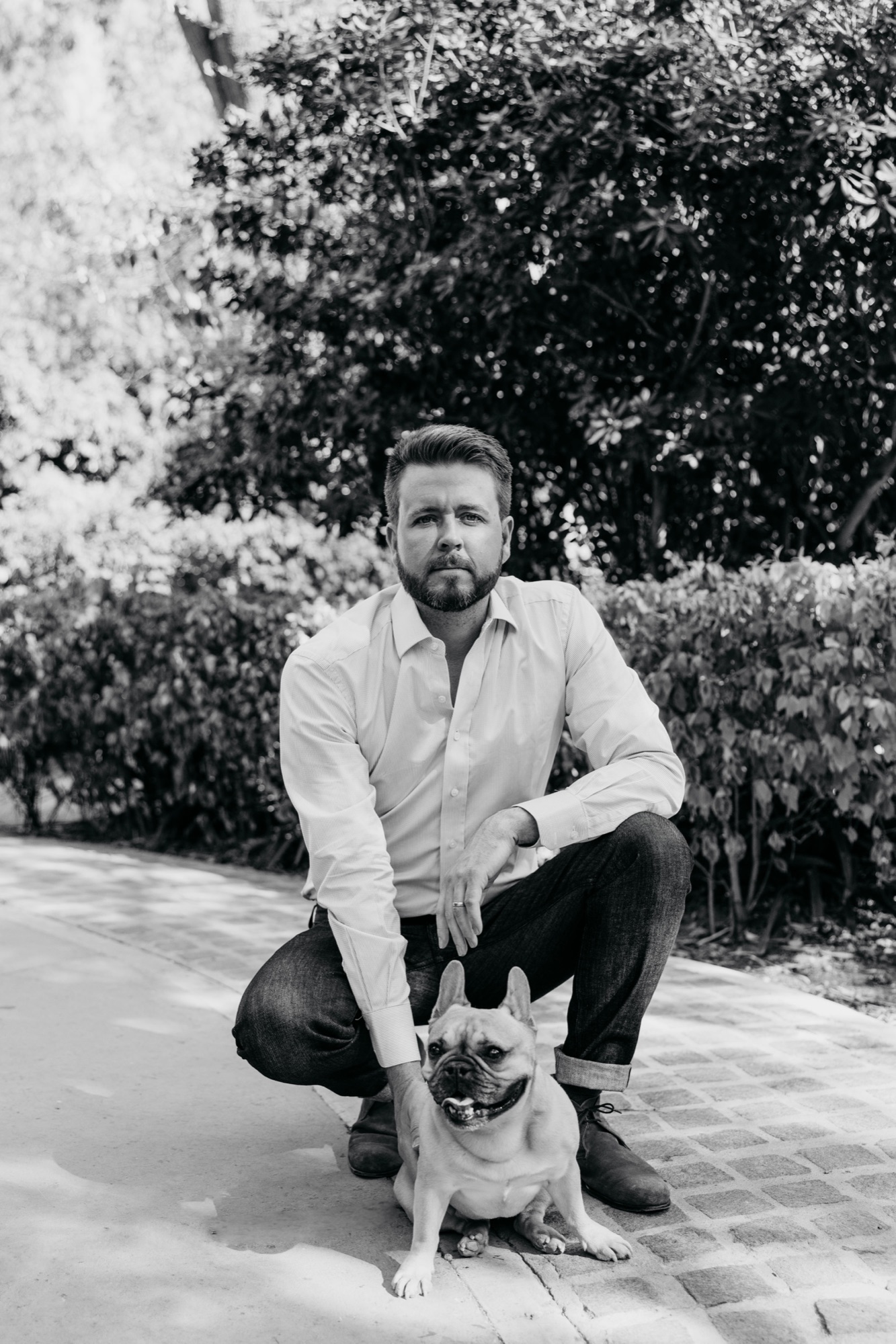 Ben crouching with his French bulldog